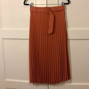 Orange pleated skirt.